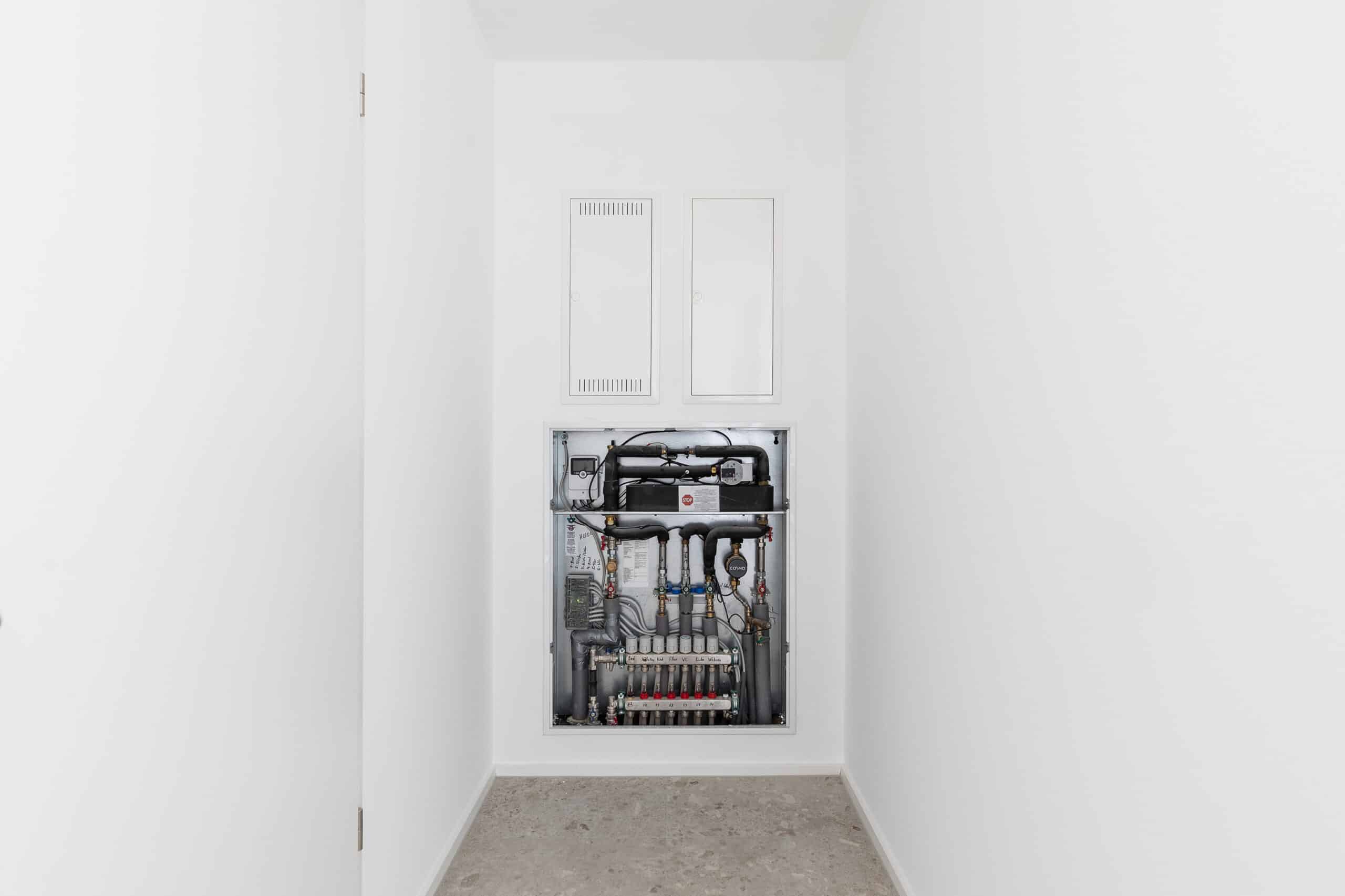 Geöffneter Einbauschrank mit Wohnungsstation und Heizkreisverteiler
