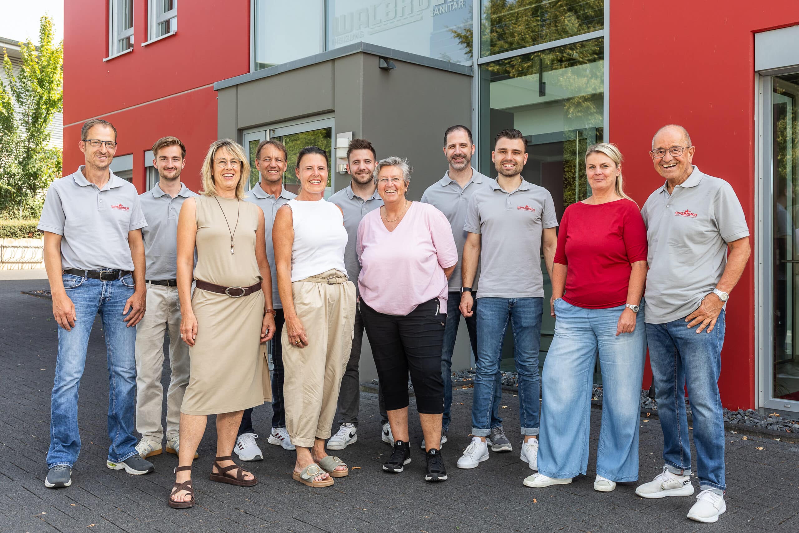 Walbrück-Team als Gruppenfoto vor dem roten Firmengebäude