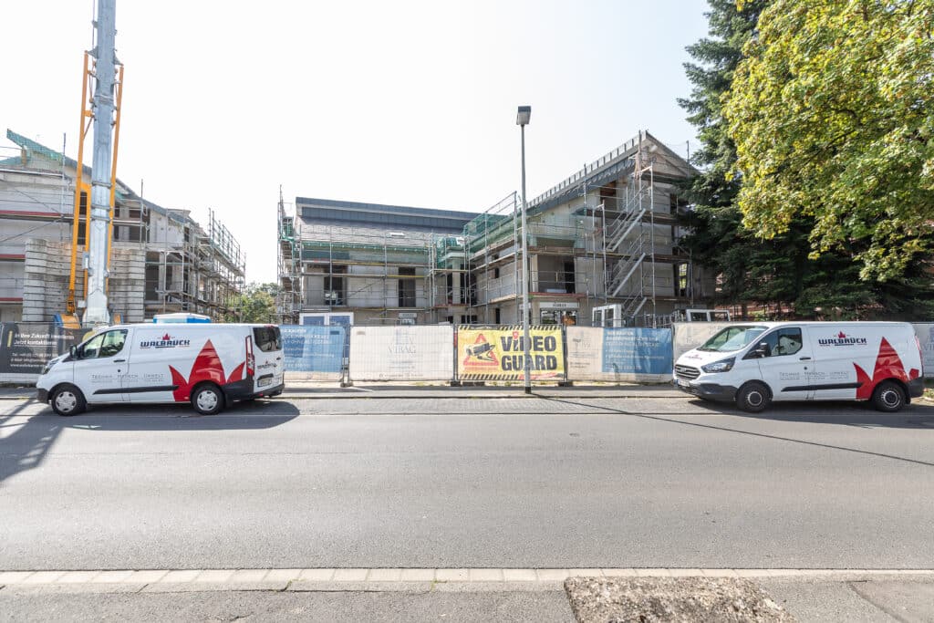Mehrere Walbrück-Servicefahrzeuge vor einem eingerüsteten Gebäude