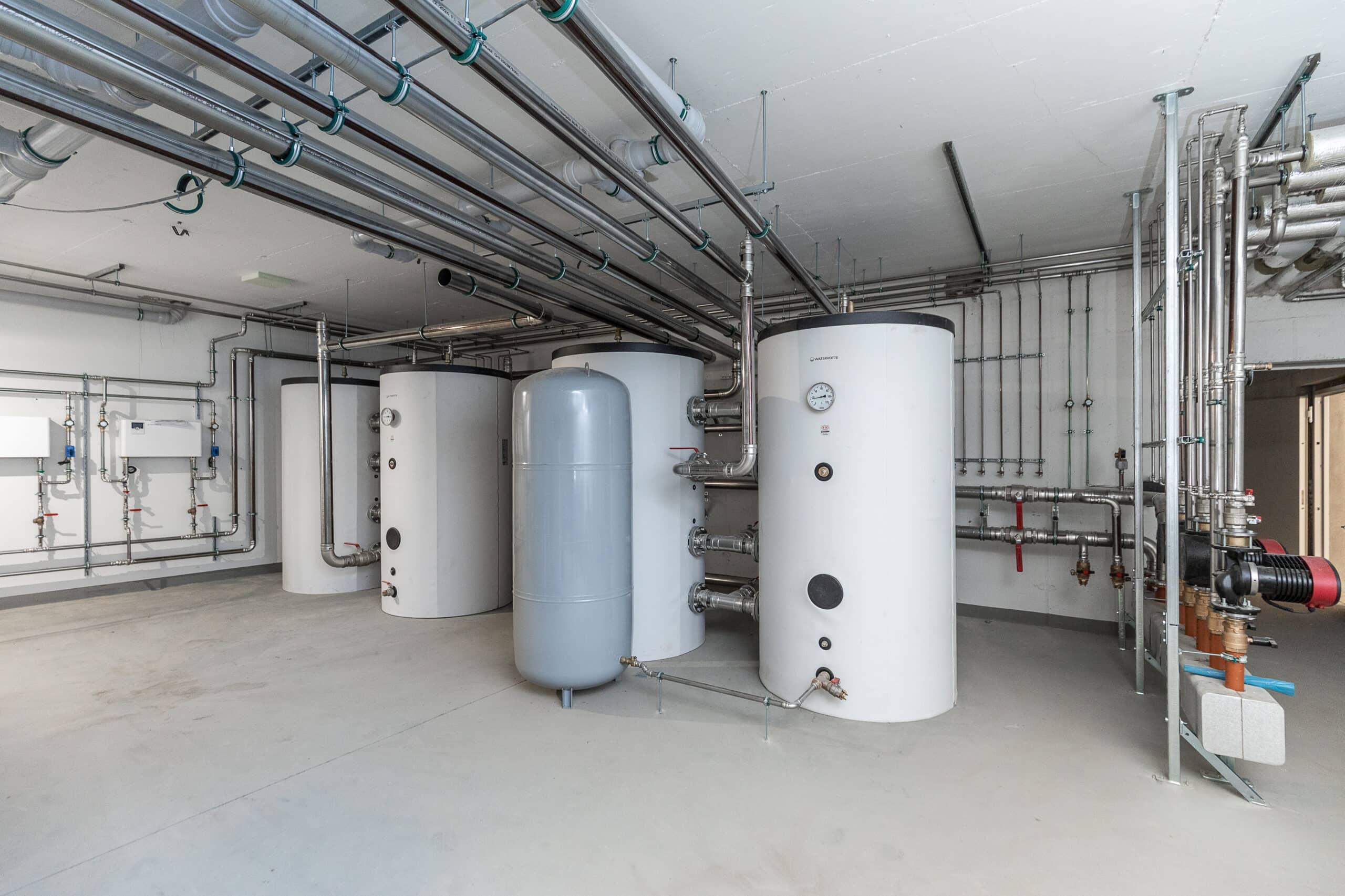Mehrere Heizungsspeicher und Rohrleitungen in einem hellen Technikraum