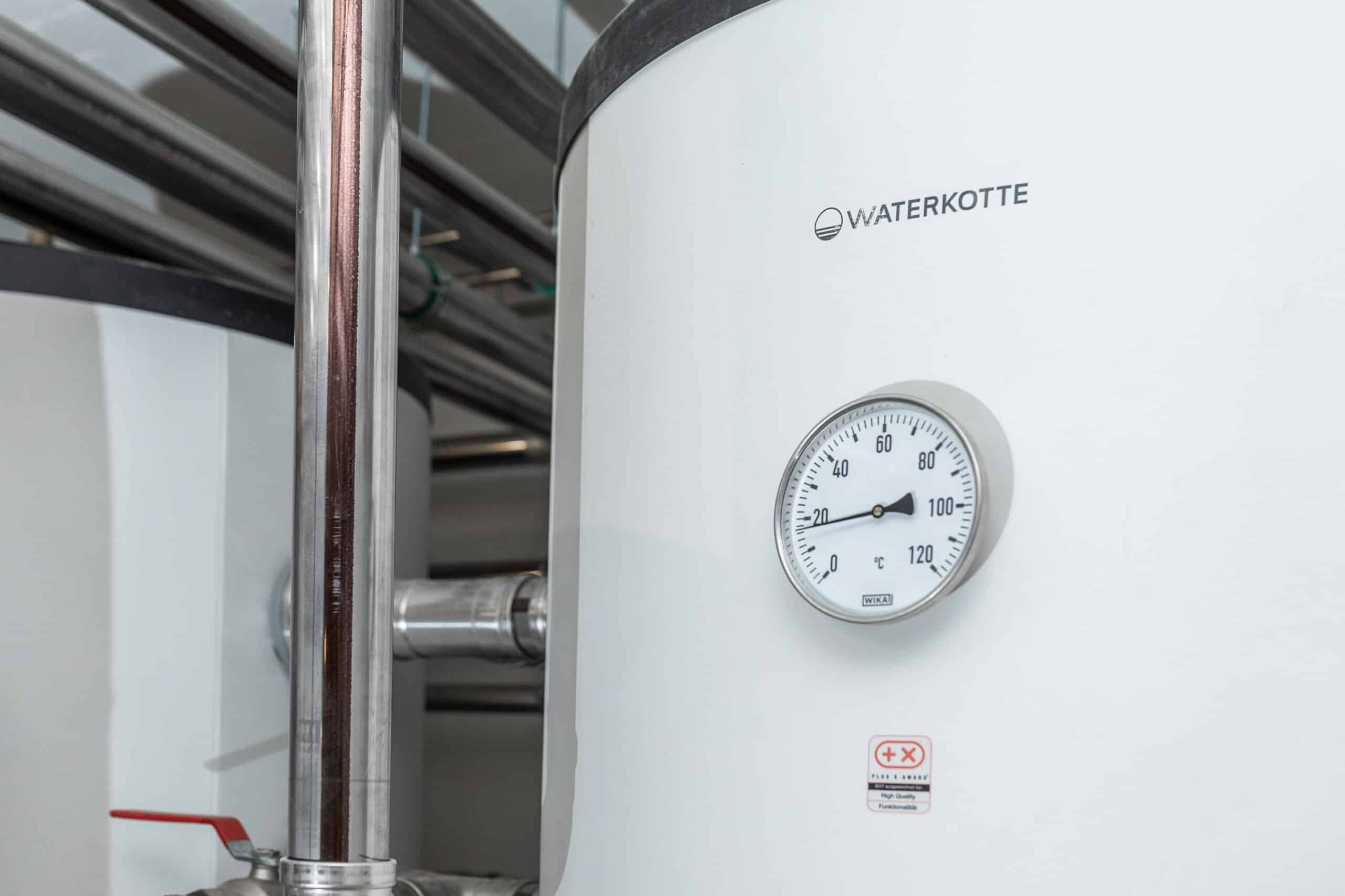 Rundes Thermometer an der weißen Verkleidung eines Waterkotte-Heizungsspeichers