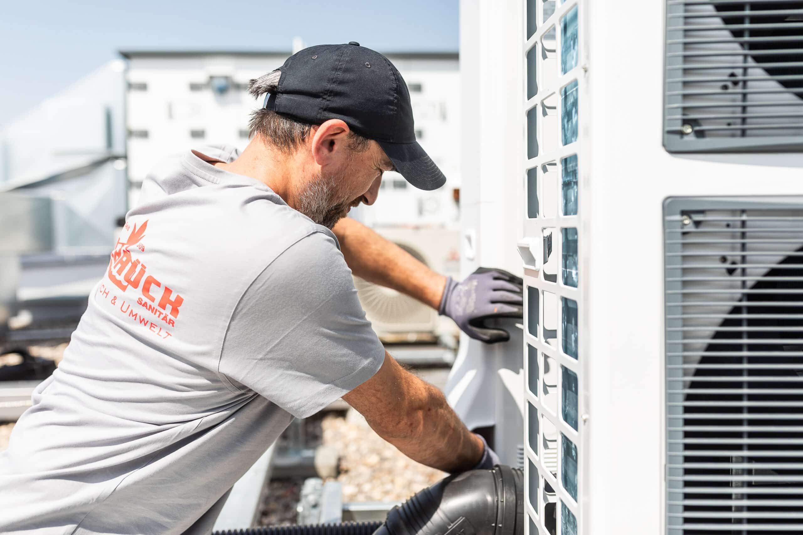Walbrück-Techniker überprüft Anschlüsse einer Wärmepumpen-Außeneinheit auf dem Dach