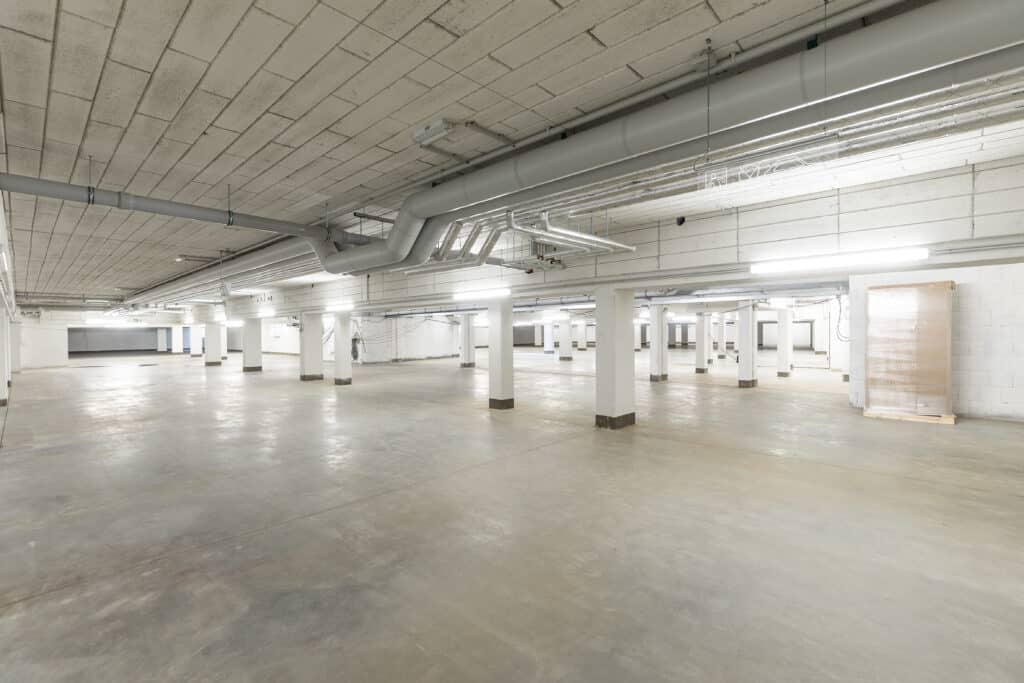 Weiträumige Tiefgarage mit Versorgungsleitungen, Lüftungskanälen und Beleuchtung