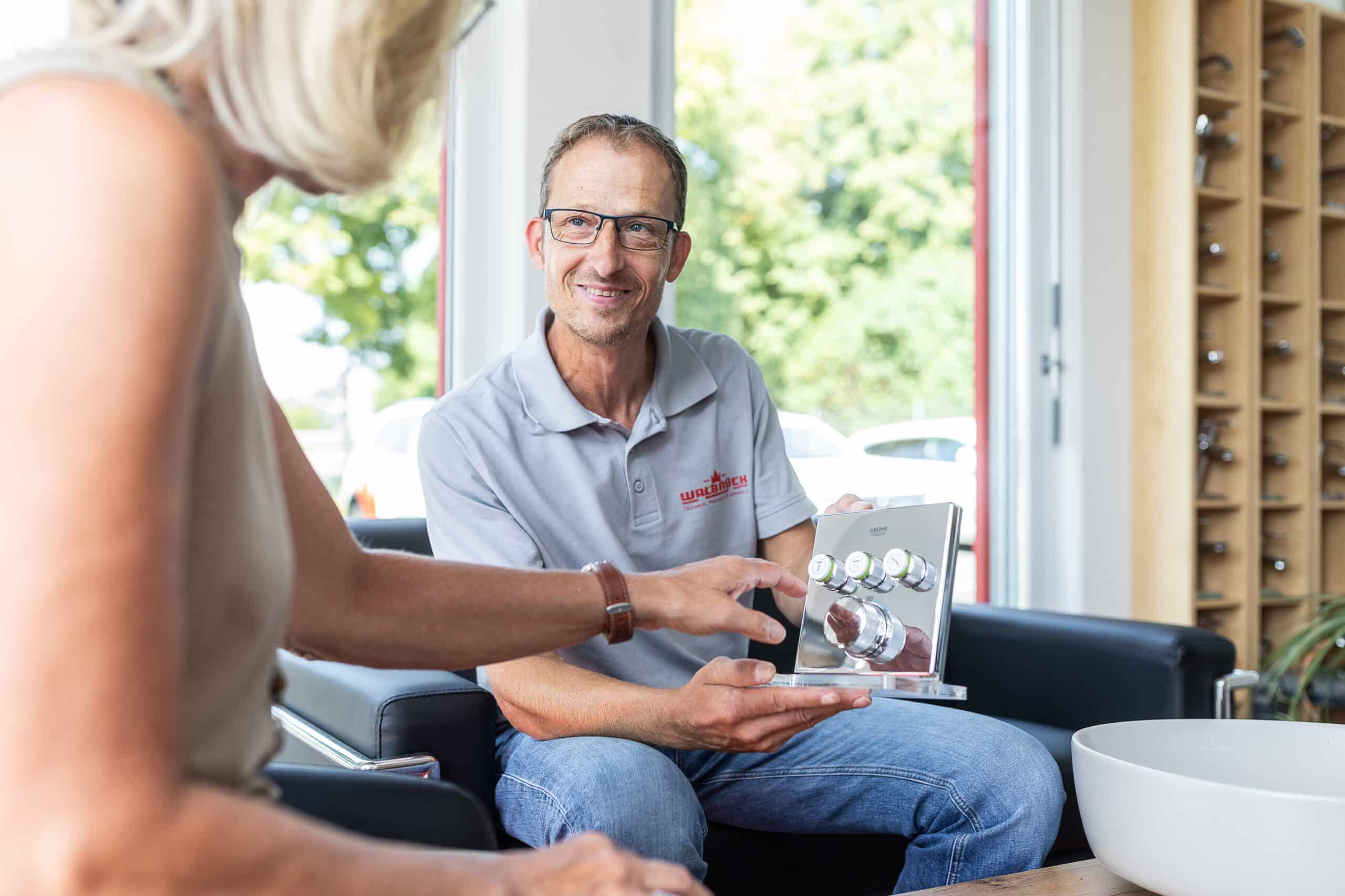 Walbrück-Mitarbeiter hält ein Armaturenmuster bei der persönlichen Badberatung