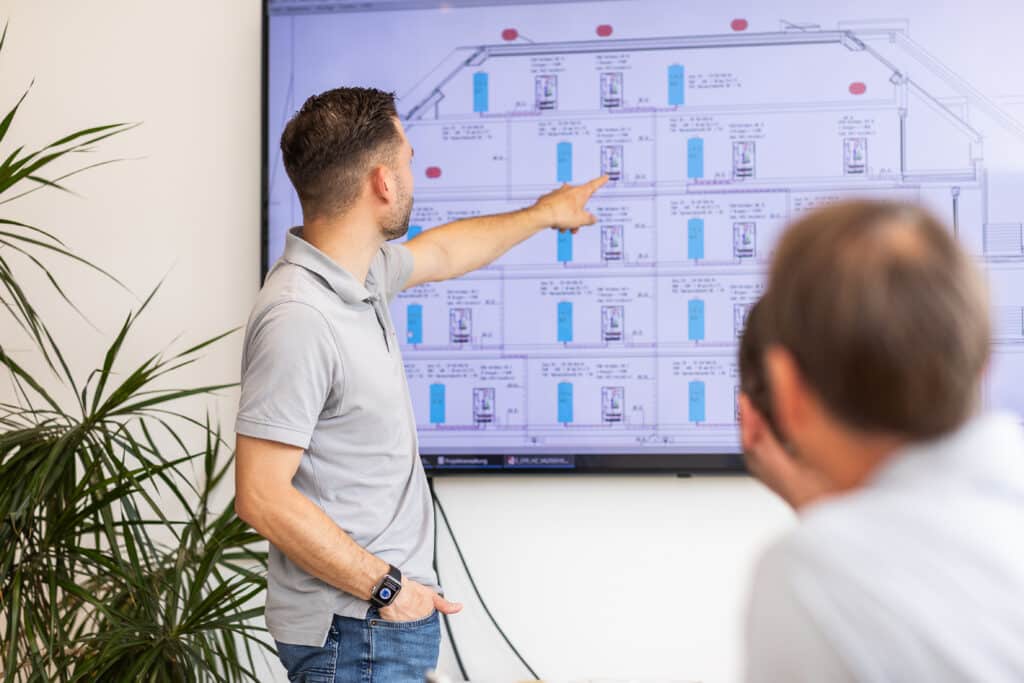 Walbrück-Mitarbeiter zeigt einem Kollegen einen technischen Anlagenplan auf einem Bildschirm